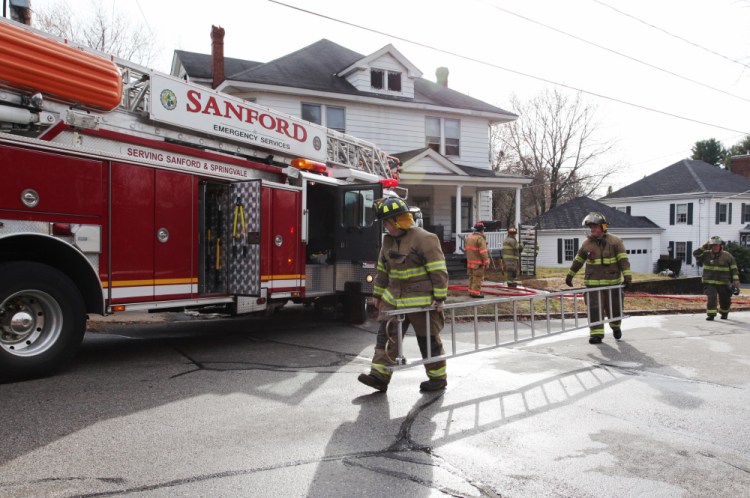 Sanford firefighters, helped by several surrounding departments, clean up after fighting a fire Saturday morning.