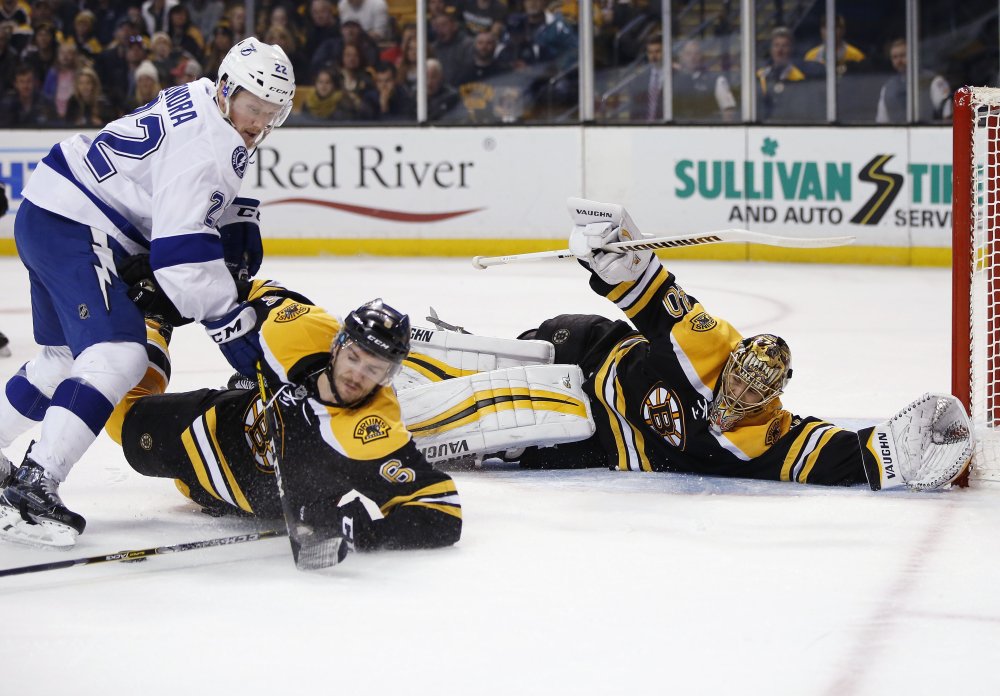 Bruins' goalie Tuukka Rask sprawls on the ice as Colin Miller, 6, defends against Tampa Bay Lightning's Erik Condra during the third period of Boston's 4-1 win Sunday in Boston.