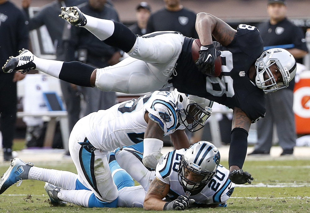 Raiders tight end Clive Walford is upended by Carolina's Kurt Coleman (20) during Oakland's 35-32 win Sunday.