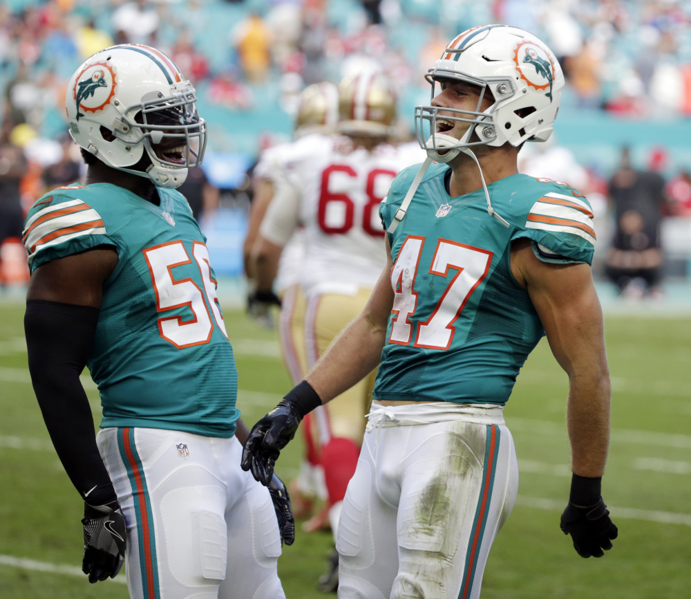 Miami's Kiko Alonso, right, celebrates an interception with teammate Donald Butler during a 31-24 win Sunday over the San Francisco 49ers at Miami Gardens, Fla.