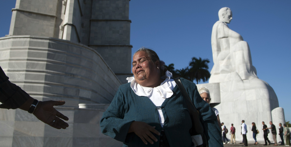 A woman weeps as she walks past the monument to independence hero Jose Marti, while paying her respects to the late Fidel Castro at Revolution Plaza in Havana, Cuba, Monday.