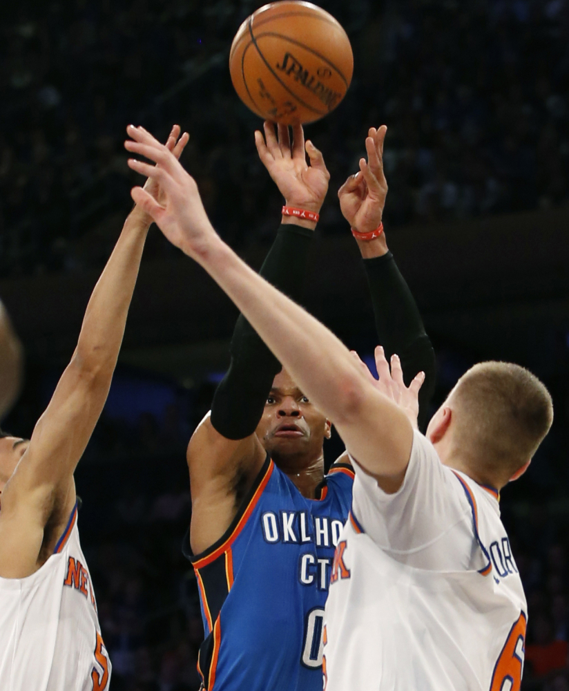 Oklahoma City guard Russell Westbrook shoots between Knicks defenders Courtney Lee, left, and Kristaps Porzingis during a 112-103 win by the Thunder at New York on Monday.