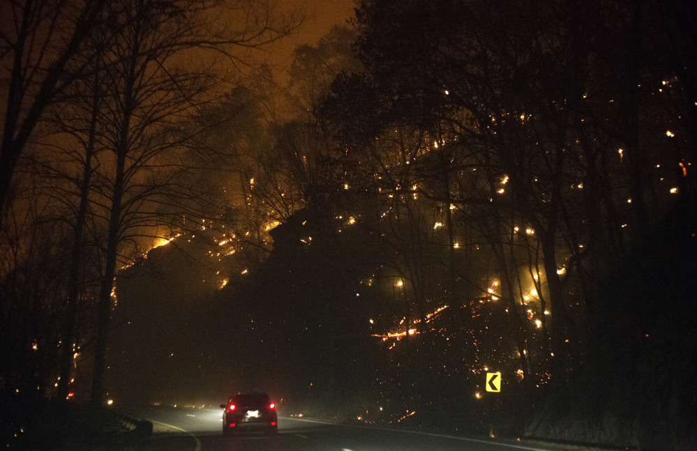 Fire erupts on both side of Highway 441 between Gatlinburg and Pigeon Forge, Tenn., Monday, Nov. 28, 2016. In Gatlinburg, smoke and fire caused the mandatory evacuation of downtown and surrounding areas, according to the Tennessee Emergency Management Agency.