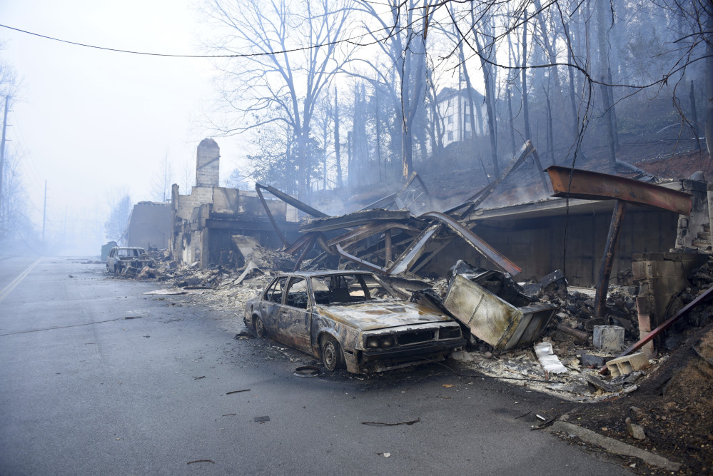 A structure and vehicle are damaged from the wildfires around Gatlinburg, Tenn., on  Tuesday, Nov. 29, 2016.  Rain had begun to fall in some areas, but experts predicted it would not be enough to end the relentless drought that has spread across several Southern states and provided fuel for fires now burning for weeks in states including Tennessee, Georgia and North Carolina.