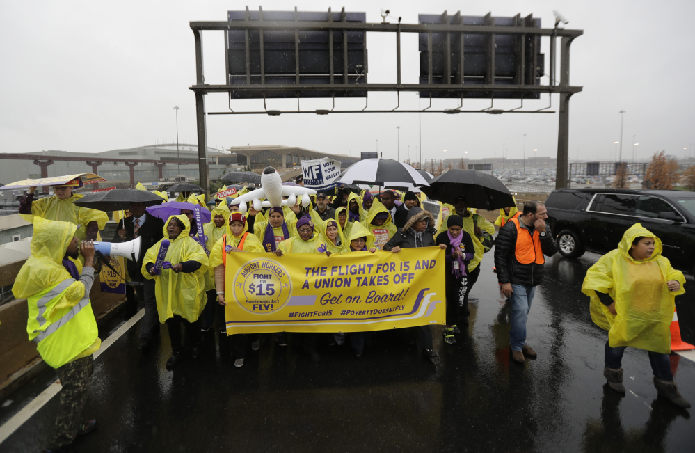 Service workers asking for $15 minimum-wage pay march on a road between terminals at Newark Liberty International Airport on Tuesday in Newark, N.J. 