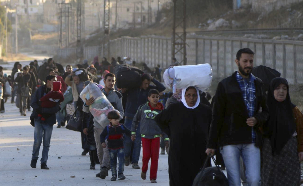 People flee rebel-held neighborhoods in eastern Aleppo on Sunday. A military official estimates that 20,000 people fled the area on Tuesday alone.