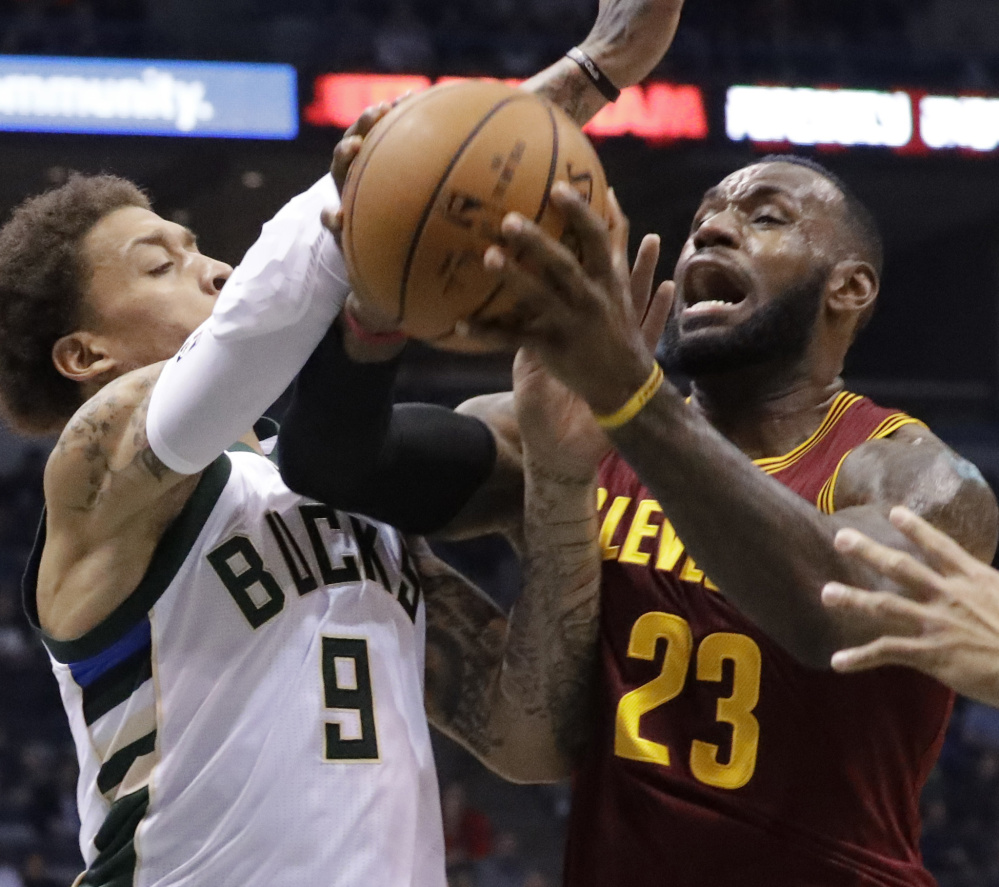 Cleveland's LeBron James is fouled by Milwaukee's Michael Beasley in the first half Tuesday night in Milwaukee. The Bucks won by 17.