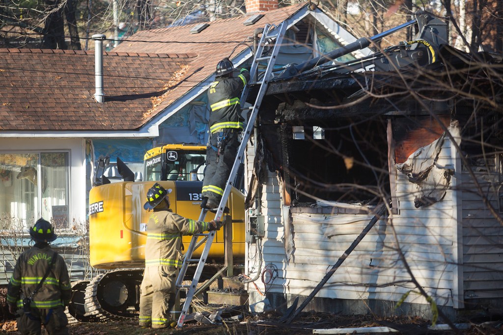 Firefighters conduct cleanup operations at 10 Pettingill Road while investigators examine the structure to try to find out what started the blaze that killed Marie McAllister Friday morning.  