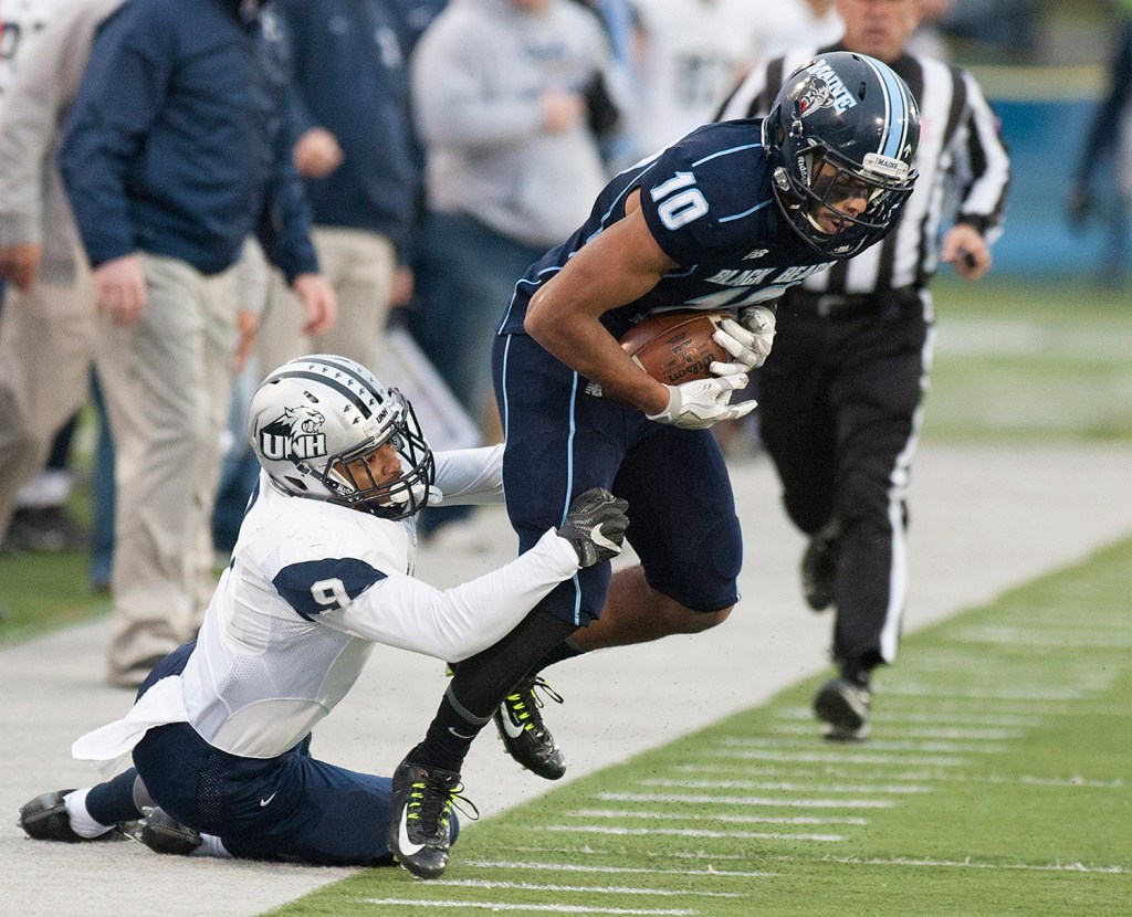 UMaine’s Micah Wright is pulled out of bounds by  UNH’s Isiah Perkins during the second half of Saturday's game in Orono.