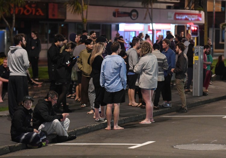 People evacuate from buildings in Wellington, New Zealand, after an earthquake on Monday.
