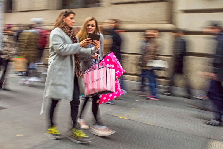 Shoppers carry their purchases on Black Friday as they walk along Fifth Avenue in New York. The U.S. economy looks healthy. The government reported Tuesday that the economy grew at a 3.2 percent annual pace from July to September, fastest in two years. Consumer spending advanced at a 2.8 percent annual pace in the third quarter, better than a previous estimate of 2.1 percent.<em> Associated Press/Andres Kudacki</em> 