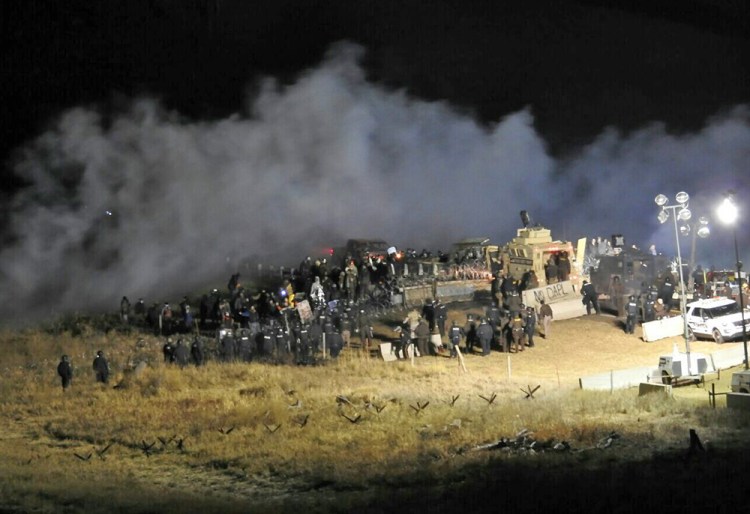 Law enforcement and protesters clash near the site of the Dakota Access pipeline on Sunday in Cannon Ball, N.D. The clash came as protesters sought to push past a bridge on a state highway that had been blockaded since late October, according to the sheriff's office. <em>Morton County Sheriff’s Department via AP</em>