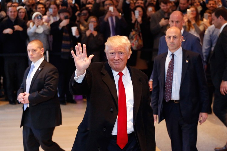 President-elect Donald Trump waves to the crowd as he leaves the New York Times building after a meeting Tuesday in New York. 