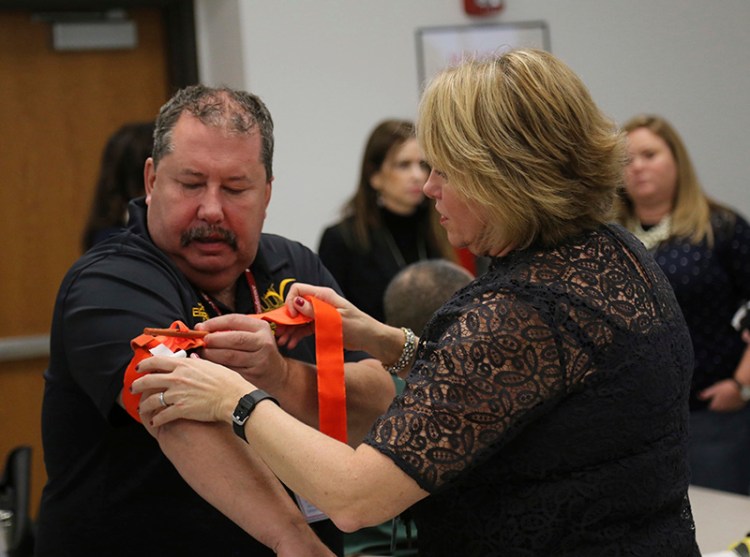 Two staffers at a school in Stony Brook, N.Y., practice applying a tourniquet to one another during a first aid training session at Stony Brook University.