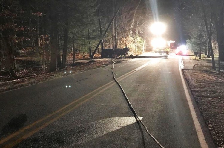 Emergency crews and police at the scene Wednesday night of a crash on Dow Road in Standish, where a  pickup truck had struck utility poles and caught fire. In the foreground is one of the downed power lines. <em>Photo courtesy of Cumberland County Sheriff's Office</em>