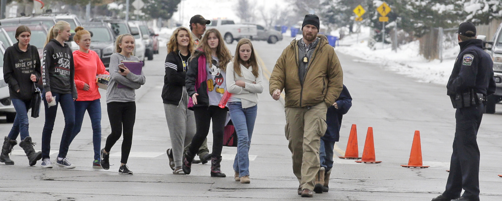 Associated Press/Rick Bowmer
A police officer escorts students after a school lockdown at Mueller Park Junior High School on Thursday in Bountiful, Utah.