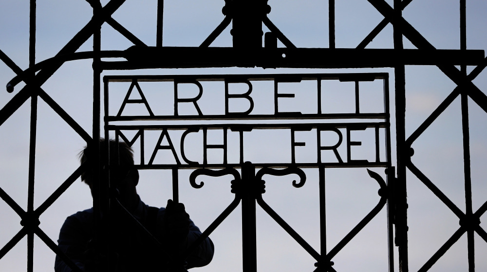 A  blacksmith prepares a replica of the Dachau camp gate last year with the German slogan for "Work sets you free."