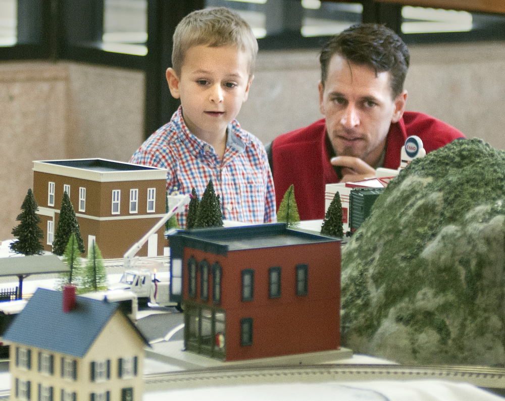 Lincoln Haiss, 5, and his father, Josh Haiss, check out a layout Friday in the atrium of the Cultural Building. The show is one of the museum's most popular events.