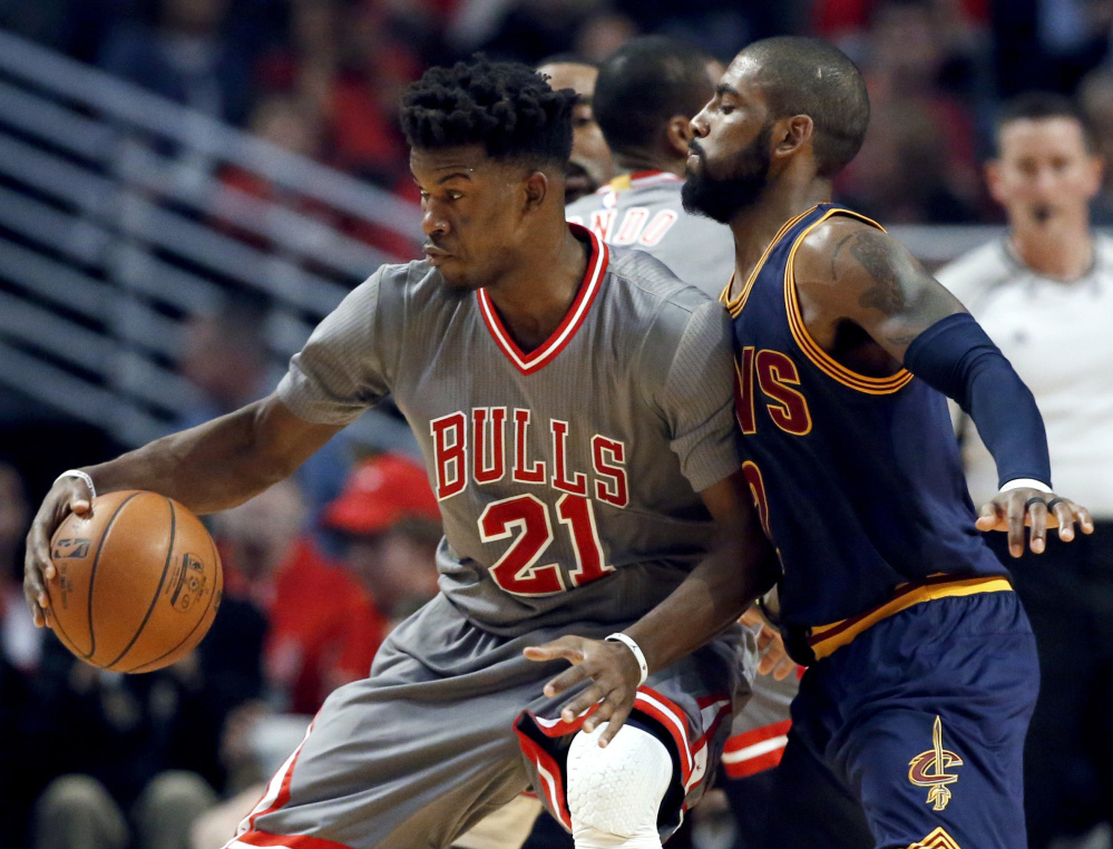 Chicago guard Jimmy Butler, left, backs into Cleveland guard Kyrie Irving during the first half of the Bulls' 111-105 win Friday night in Chicago. Butler led the Bulls with 26 points while the Cavaliers lost their third straight game.