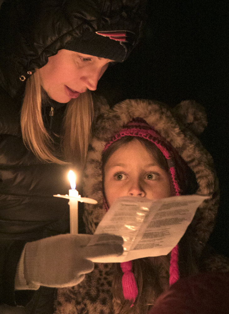 Rebecca Plamondon of Kennebunkport, left, and her daughter Ayla go caroling at the Franciscan monastery in Kennebunk during Christmas Prelude on Saturday.
Gregory Rec/Staff Photographer