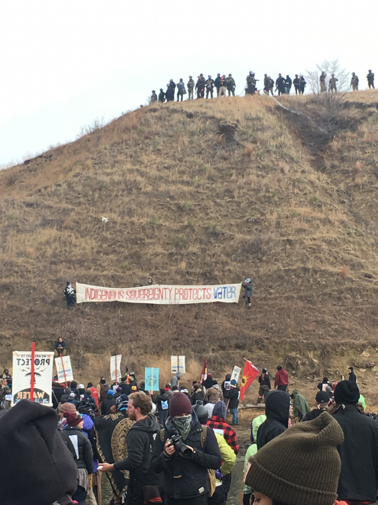 Armed police convene on top of Turtle Island in North Dakota as protesters stand in solidarity with the Standing Rock Sioux, who are fighting to protect their water source by blocking the Dakota Access Pipeline. Among the protesters has been May Aihua Ye, a Waterville native.