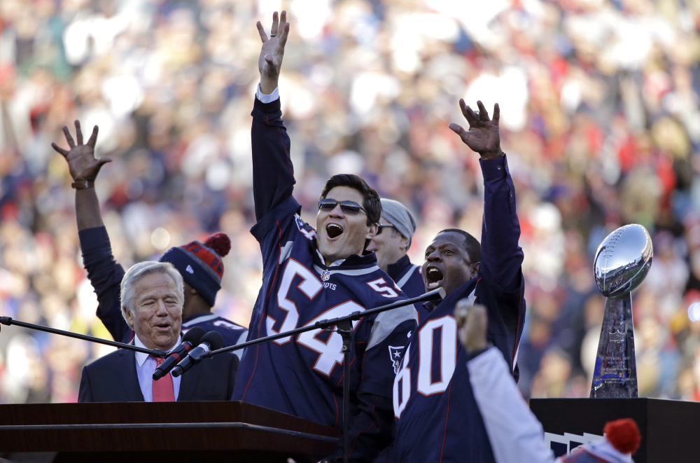 Tedy Bruschi, center, and Troy Brown, right, cheer with the New England Patriots' owner, Robert Kraft, while being honored at halftime Sunday, coming together 15 years after leading the franchise to the first of its four Super Bowl championships.
