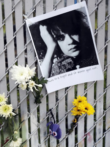 Pictures and flowers adorn a fence Monday near the site of the warehouse fire in Oakland, Calif. The death toll climbed Monday with more bodies still feared buried in the blackened ruins. Associated Press/Marcio Jose Sanchez