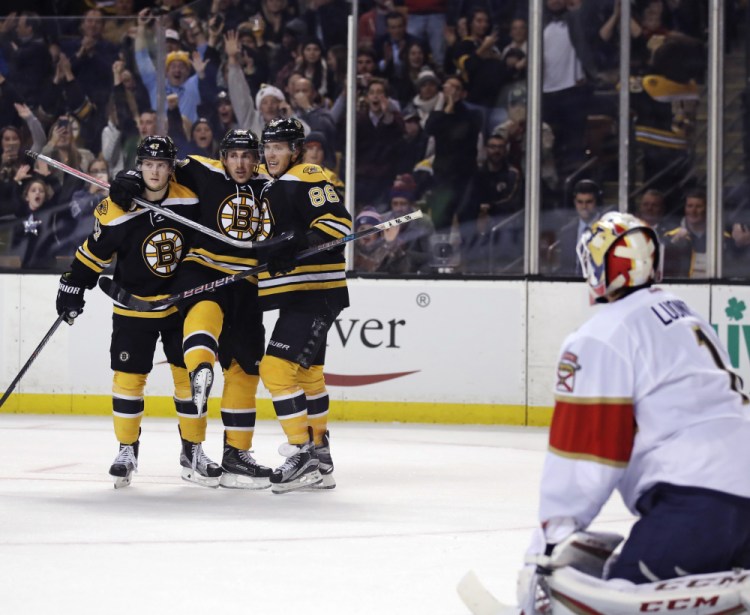 Bruins right wing David Pastrnak (88) is congratulated by teammates Torey Krug (47) and Brad Marchand after his goal against Panthers goalie Roberto Luongo in the second period Monday night in Boston. The Bruins went on to win 4-3 on an overtime goal by Pastrnak.