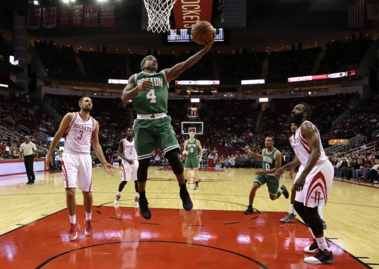 The Celtics' Isaiah Thomas goes up for a layup as Houston Rockets Ryan Anderson (3) and James Harden, right, watch in the first half of Monday night's game in Houston. Harden had 37 points to lead the Rockets.