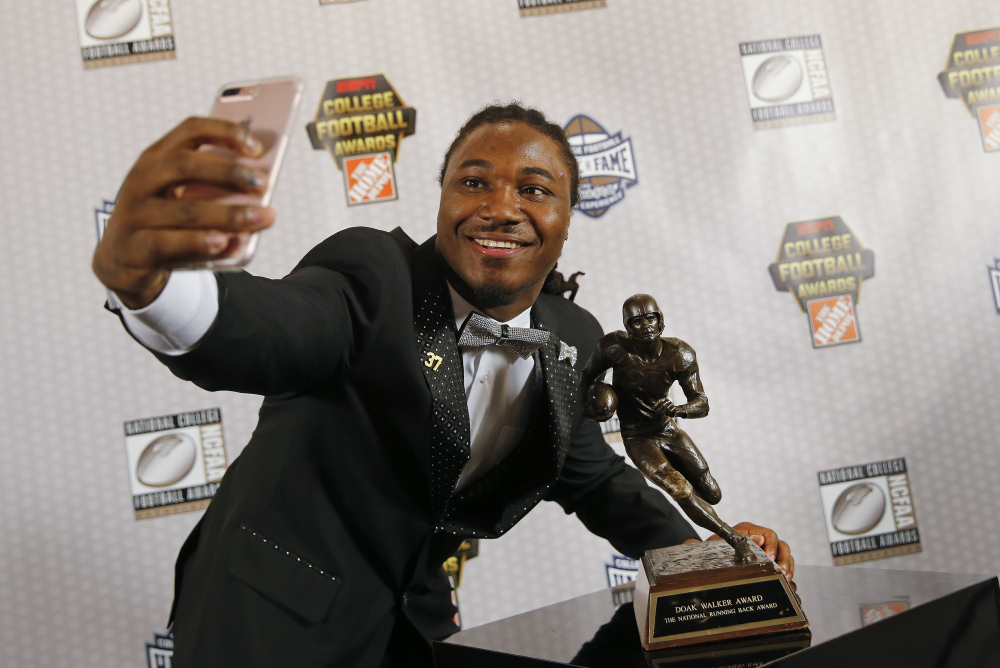 Texas running back D'Onta Foreman takes a selfie with the Doak Walker Award on Thursday after winning it for being the nation's premier running back. Foreman has rushed for 2,028 yards this season.