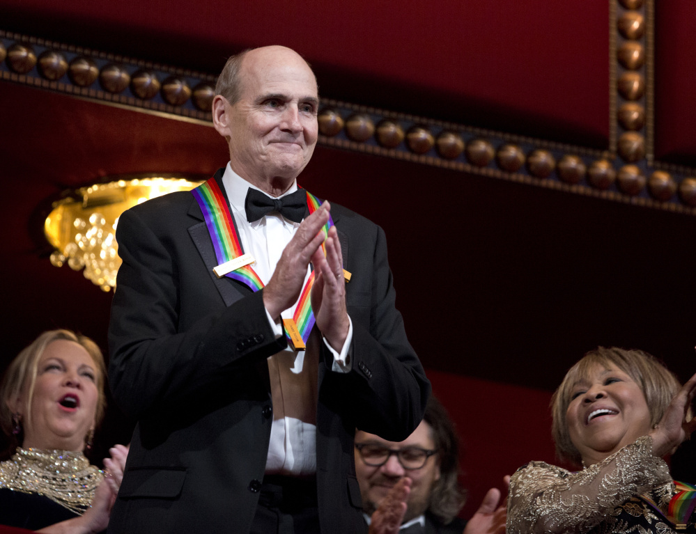 James Taylor acknowledges the applause during the Kennedy Center Honors gala. At right is fellow honoree Mavis Staples.