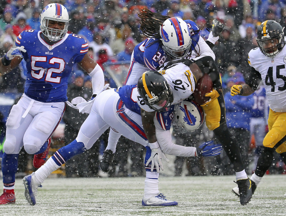Steelers running back Le'Veon Bell is tackled by Buffalo's Ronald Darby, top, and Corey Graham during Sunday's game in Orchard Park, N.Y. Bell collected almost 300 yards rushing and receiving and scored all three Pittsburgh touchdowns in a 27-20 victory.