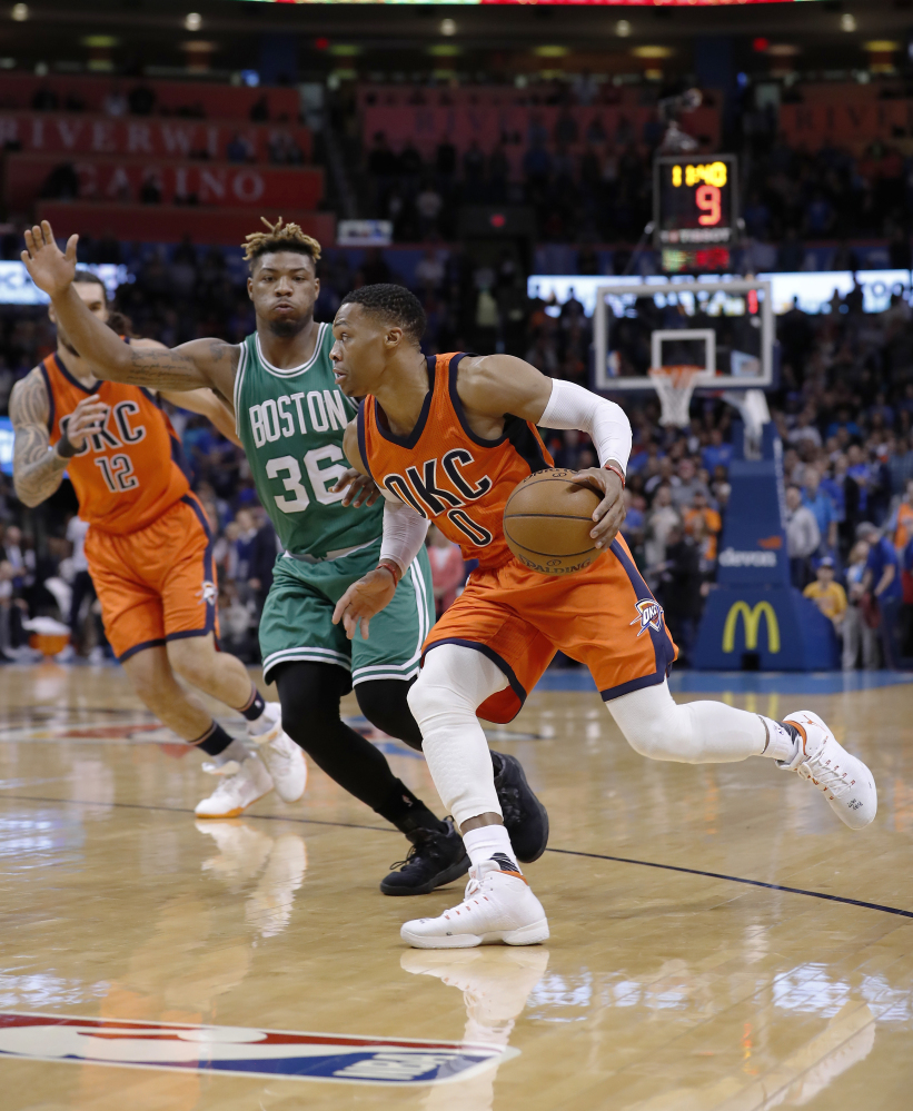 Oklahoma City Thunder guard Russell Westbrook (0) drives to the basket around Boston Celtics guard Marcus Smart (36) during the first half.
