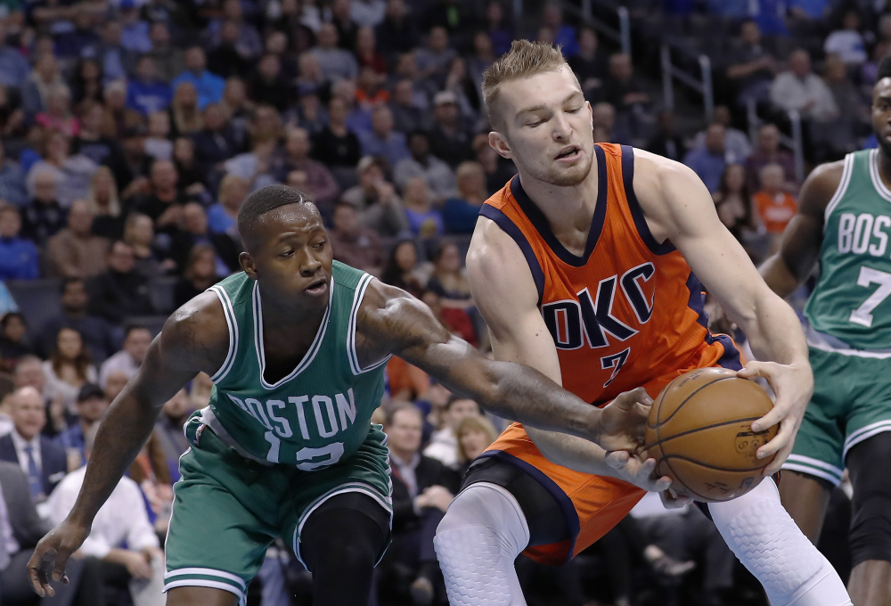 Boston Celtics guard Terry Rozier (12) and Oklahoma City Thunder forward Domantas Sabonis (3) fight for a loose ball during the first half of Sunday's game in Oklahoma City. Photo by Alonzo Adams/Associated Press