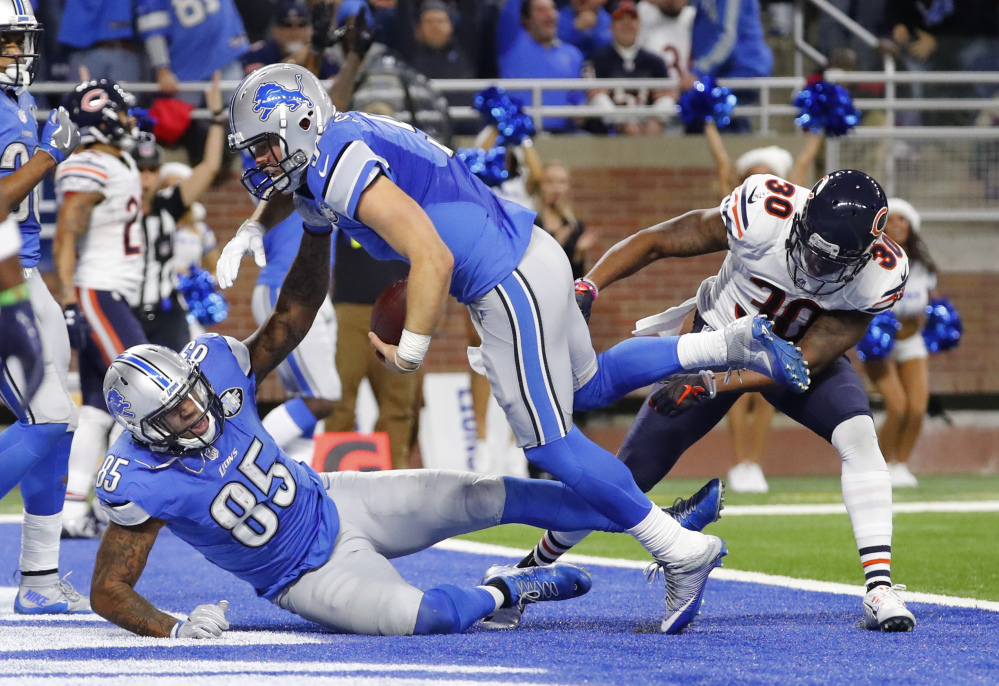 Detroit Lions quarterback Matthew Stafford (9) runs over tight end Eric Ebron (85) for a 7-yard touchdown against the Chicago Bears in the second half of an NFL football game in Detroit, Sunday, Dec. 11, 2016. (AP Photo/Rick Osentoski)