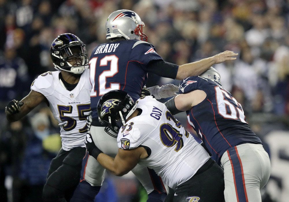 Ravens defensive end Lawrence Guy hits Tom Brady as he throws an interception in the first half. It was just the second interception of the season for Brady, but it was the first of three turnovers for the Patriots.