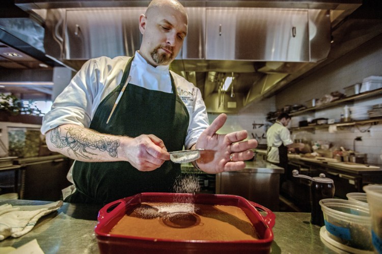 Josh Berry dusts Indian pudding with powdered sugar at Union restaurant in the Press Hotel.