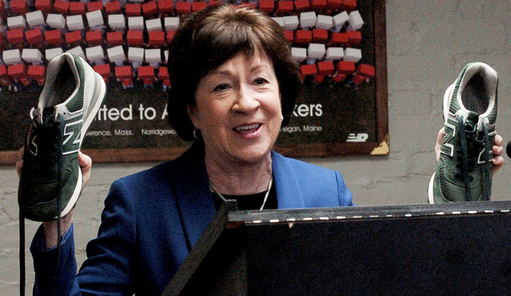 Sen. Susan Collins holds up a pair of New Balance sneakers monogrammed with her husband's initials during.