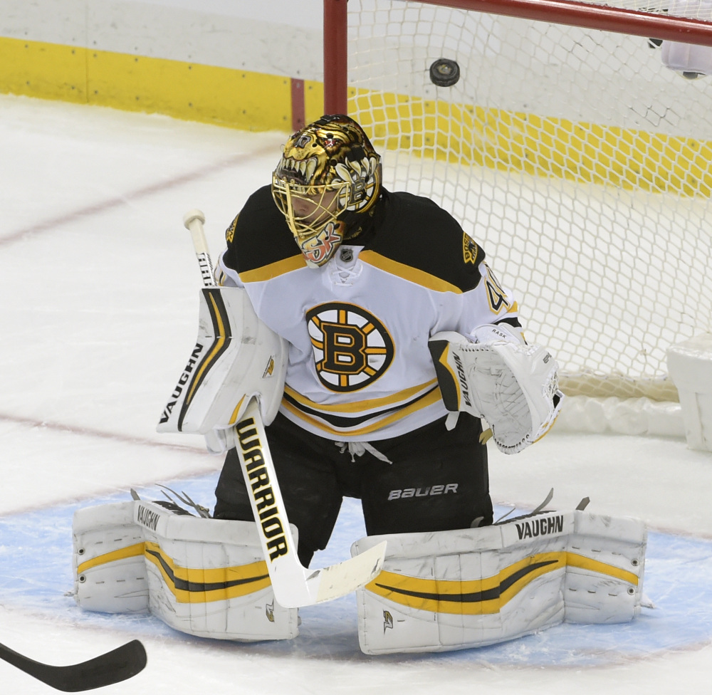 A shot by Penguins defenseman Justin Schultz goes into the net past Bruins goalie Tuukka Rask in the first period.