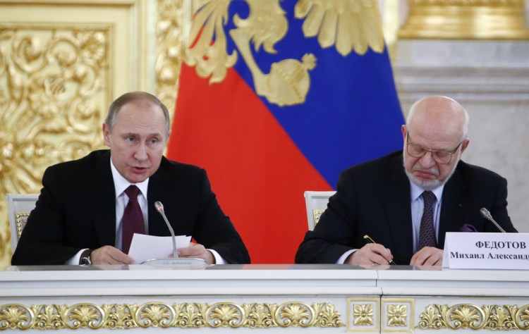 Russia's President Vladimir Putin, left, delivers a speech during a session of the Council for Civil Society and Human Rights, as its chairman Mikhail Fedotov sits at right at the Kremlin in Moscow, Russia, on Thursday.