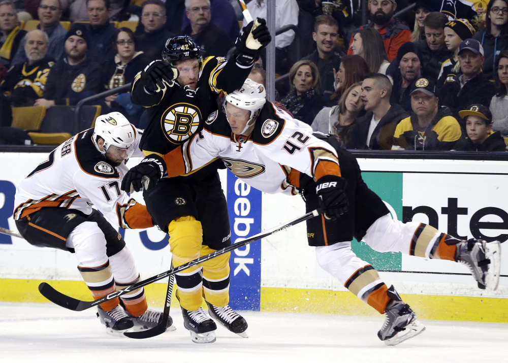 Bruins right wing David Backes gets squeezed between Ducks center Ryan Kesler (17) and defenseman Josh Manson in the second period. Anaheim took the lead in the period and never gave it up.