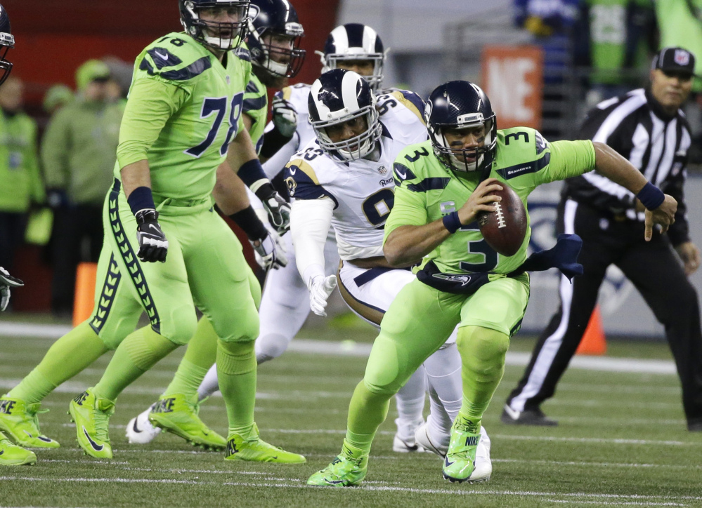 Seattle Seahawks quarterback Russell Wilson threw for three touchdown passes on a 24-3 win over the Los Angeles Rams on Thursday in Seattle. (Associated Press/Elaine Thompson)