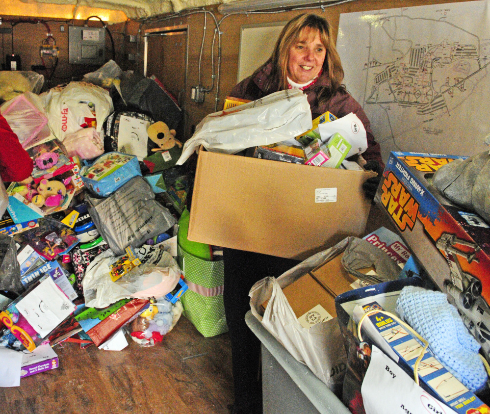 Glenda Robertson carries a load of toys donated by her co-workers at VA Maine Healthcare Systems-Togus to the Salvation Army Capital Region center in Augusta on Friday. Robertson and five other volunteers delivered items.