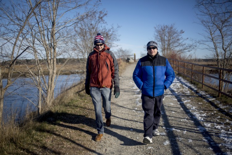 Ron Currier, left, and Jack Currier, of Scarborough, walk along the section of the Eastern Trail that goes through the Scarborough Marsh. The $100,000 gift will be earmarked to build a bridge over the Nonesuch River, filling a gap in the trail between Scarborough to South Portland. <em>Brianna Soukup/Staff Photographer</em>