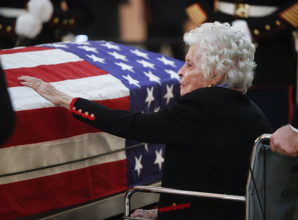 Annie Glenn touches the casket of her late husband John Glenn as he lies in honor Friday in Columbus, Ohio.