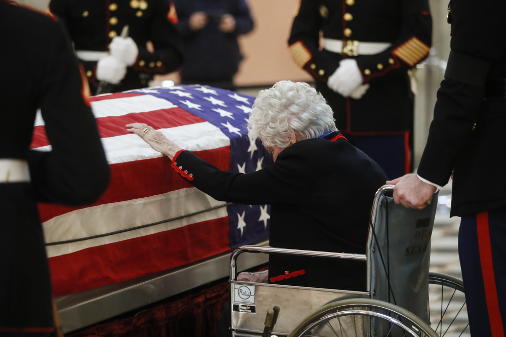 Annie Glenn touches the casket of her husband John Glenn as he lies in honor, Friday, Dec. 16, 2016, in Columbus, Ohio. Glenn's home state and the nation began saying goodbye to the famed astronaut who died last week at the age of 95. (AP Photo/John Minchillo)