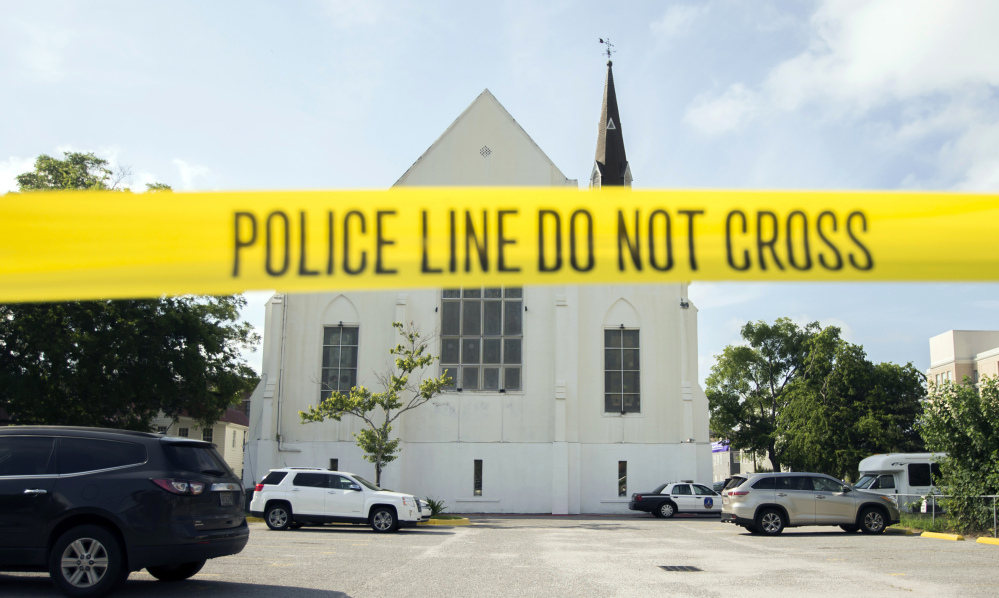 Police tape surrounds the parking lot behind the AME Emanuel Church where Dylann Roof shot and killed nine members of the church Bible study. Some in Charleston are struggling with the concept of forgiving Roof.