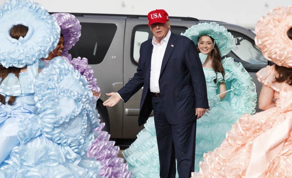President-elect Donald Trump is greeted by the Azalea Trail Maids – goodwill ambassadors for Mobile, Ala. – after arriving at the local airport for a rally at Ladd-Peebles Stadium, Saturday, where he had the biggest rally of his campaign earlier this year. As Trump wraps up his victory tour in the South, he shows few signs of turning the page from his blustery campaign, gloatingly recappiong his Election Night triumph and doing little to quiet the chants of "Lock up up!" directed at Hillary Clinton.