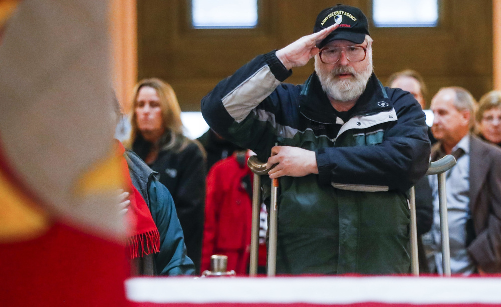 A mourner salutes the casket of John Glenn as he lies in state Friday in Columbus, Ohio. The former fighter pilot, astronaut and Democratic senator died Dec. 8 at 95.