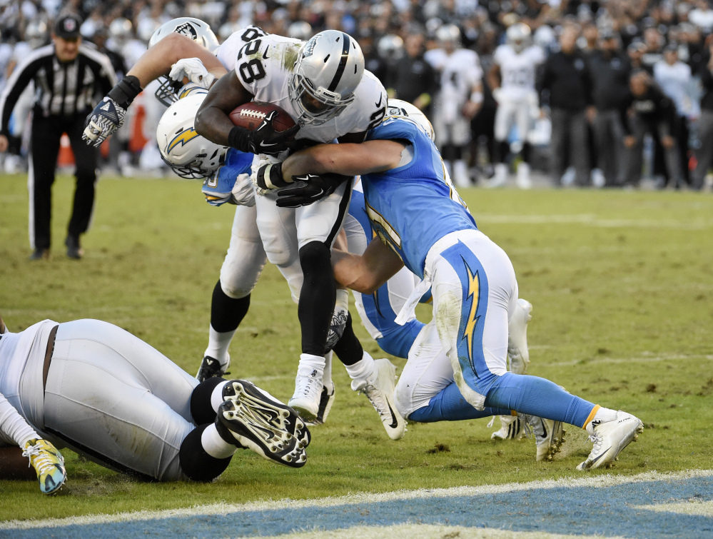Oakland Raiders running back Latavius Murray (28) is held out of the end zone by San Diego Chargers outside linebacker Kyle Emanuel, right, and defensive end Joey Bosa, behind, during the second half of an NFL football game Sunday, Dec. 18, 2016, in San Diego. (AP Photo/Denis Poroy)